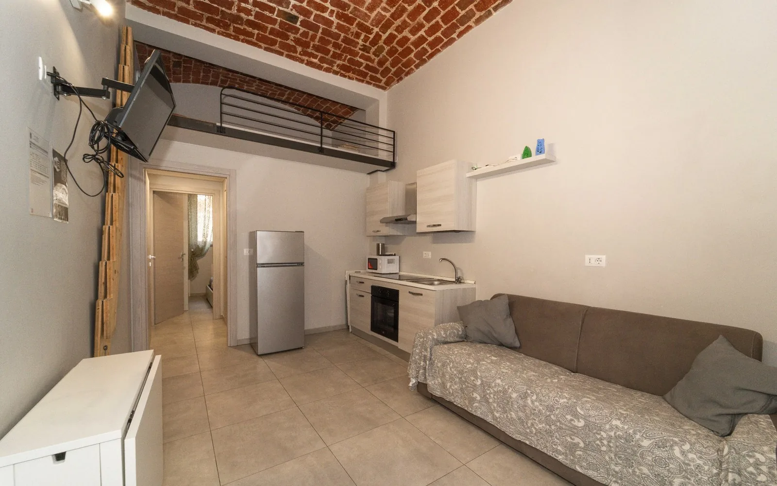 Alloggio COBER IMMOBILIARE a Torino: zona giorno con divano, angolo cottura e soppalco
