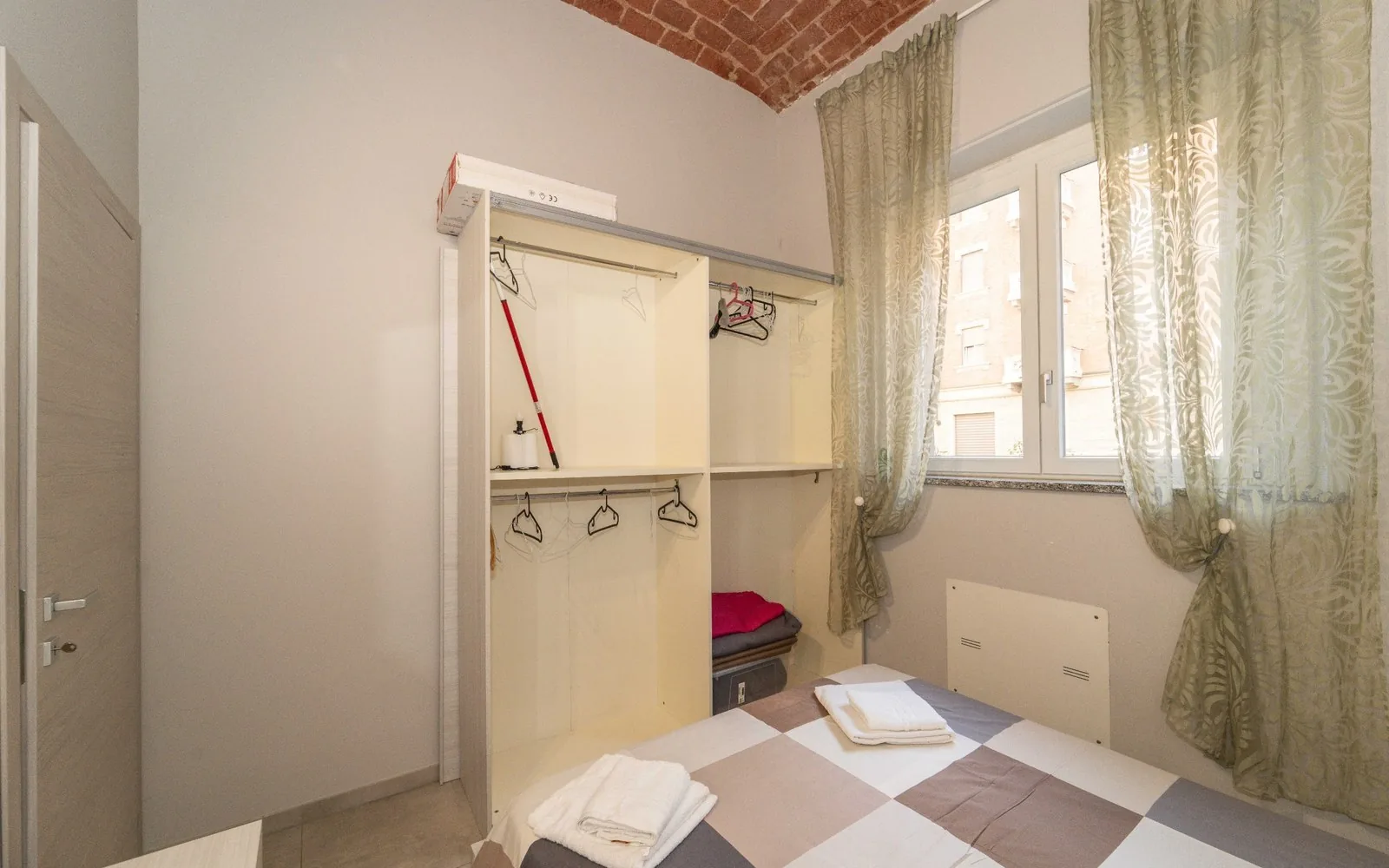 Camera matrimoniale con finestra e tende chiare in un bilocale COBER IMMOBILIARE a Torino