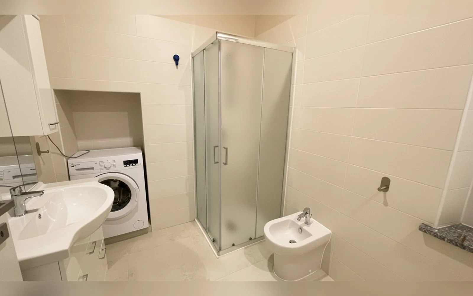Bagno privato con doccia, lavabo e lavatrice in un appartamento COBER IMMOBILIARE a Scarmagno