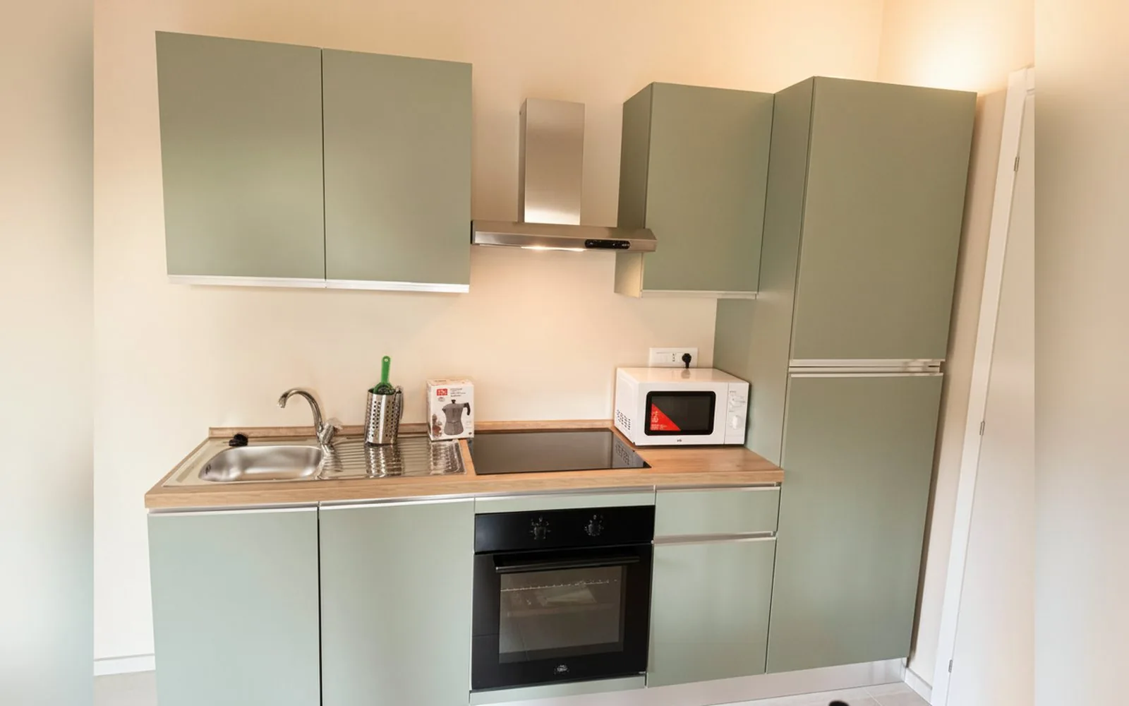 Cucina completa con forno, microonde e piano a induzione in un appartamento COBER IMMOBILIARE a Scarmagno